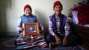 Nimdige Sherpa con un retrato de Ang Kaji Sherpa, fallecido en la avalancha en el Everest. A su lado, su esposo Anckhu Sherpa